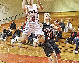 HIGH FLYING CARDINAL: Jillian Halfhill (4) drives to the bucket as North Canton Hoover's Jessica Carpenter (33) plays defense during Wednesday's game in Canfield. The Vikings tripped up the Cardinals, 48-45, with a winning layup and free throw by Allison Pearce.