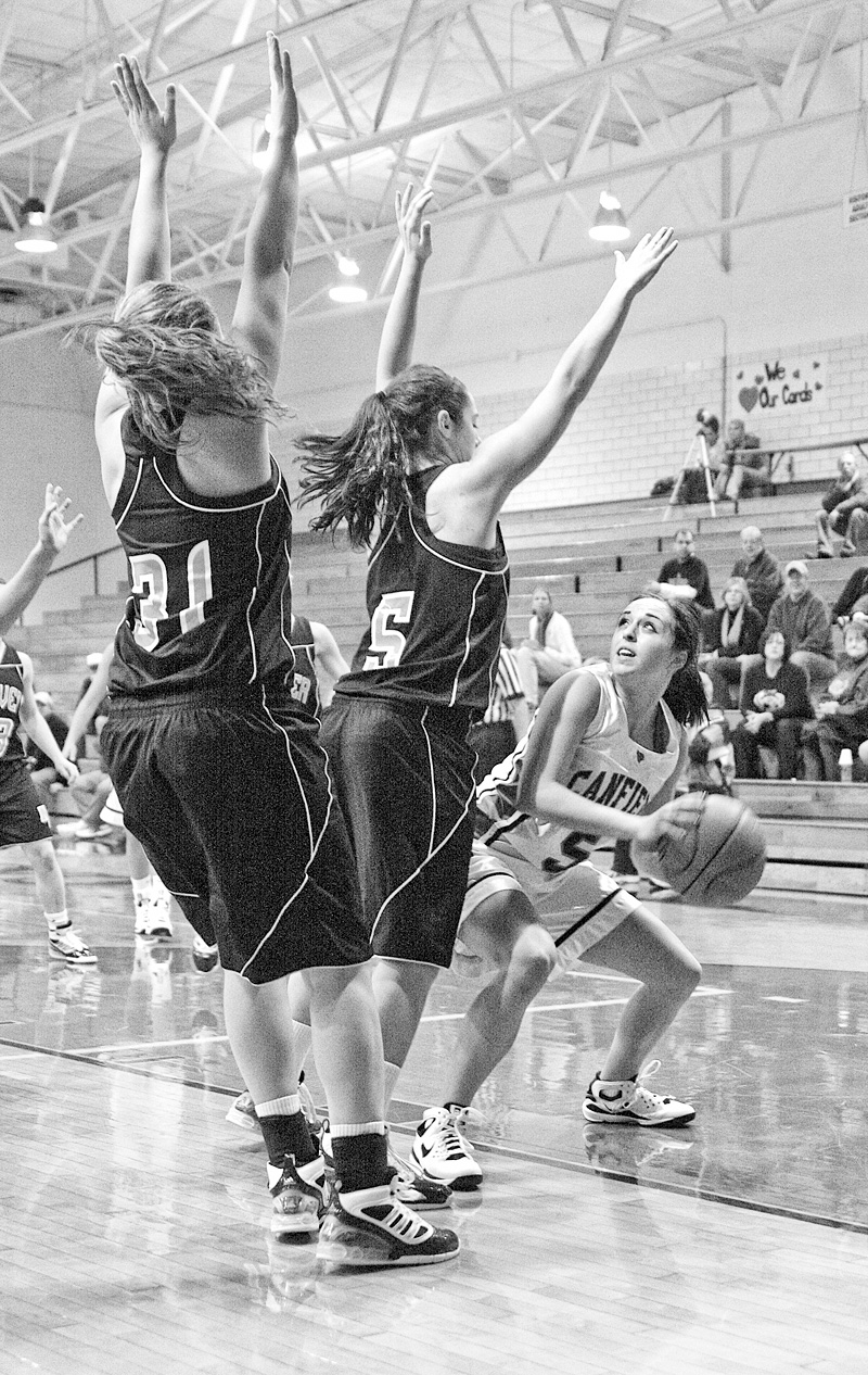 NOT MAKING IT EASY: Hoover defenders Erika Warren (5) and Eleni Bourlas (31) try to keep Canfeild's Rachael O'Hara (5) from the hoop during Wednesday's game in Canfield.