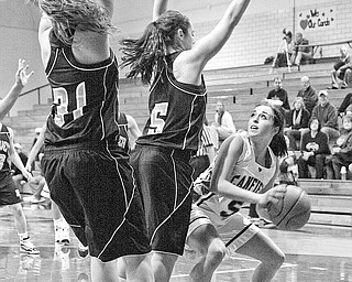 NOT MAKING IT EASY: Hoover defenders Erika Warren (5) and Eleni Bourlas (31) try to keep Canfeild's Rachael O'Hara (5) from the hoop during Wednesday's game in Canfield.
