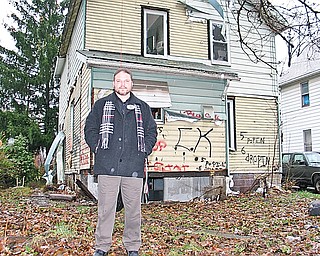 SLUM BUSTER: Warren Police Detective Patrick Marsico has focused his energy since November on charging the owners of Warren condemned homes with a criminal offense for failing to demolish or repair the homes. Marsico stands in the rear yard of a condemned home on Haymaker Avenue Northwest, a street hit hard by local housing and economic conditions. The house is missing much of its aluminum siding, has broken windows, trash and even missing cement blocks.