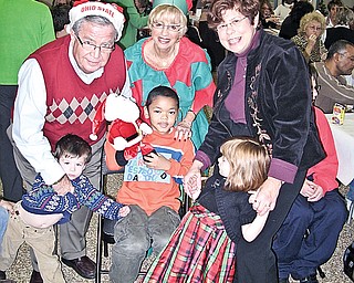 FOR THE KIDS: Children, parents and staff of The Rich Center for Autism enjoy food, music and seasonal fun at the third annual holiday party sponsored by Merv and Marlene Hollaner. Merv Hollander, his wife, Marlene, and Bernadette Kovach share in the fun with center pupils, from left, Colin Brogan, Nathan Tucker and Ellie Brogan.