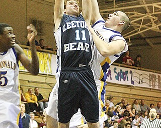 REACHING FOR IT: Leetonia's Matt Newton (11) is fouled by McDonald's David JOhn as he dives to the oop in Friday's game in McDonald. The Blues Devils defeated the Bears, 68-55.