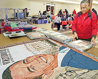 WORK OF ART: Marsha Dykes of Girard displays tapestry throws she had for sale at a Kwanzaa event at the Buckeye Elks on North Avenue in Youngstown. The event was Monday night. The merchandise featured the likeness of President-elect Barack Obama and other black American history makers.