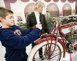 Dillwyn Damiani, age 11 of Alliance, takes a photograph of a 1913 Sears DeLuxe Invincible Twin alongside his mother Linda Damiani while viewing the Antique Motorcycle Show at the National Packard Museum in Warren. Approximately 30 bikes are on display until May 31st with models dating back to 1902 and several bikes having been made in ohio. The National Packard Museum at 1899 Mahoning Ave. in Warren is opened Tuesday-Saturday 12pm-5pm and Sunday 1pm-5pm.