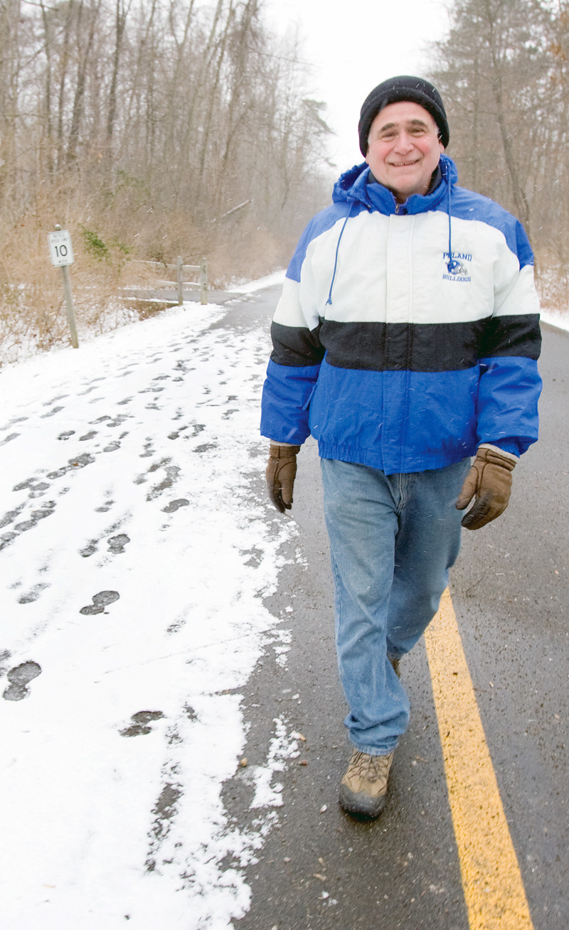 TAKING A WALK: Dave DiRienzo, 55, of Beaver Township, walks along East Golf Drive at Mill Creek MetroPark. DiRienzo, a teacher in Poland, said he typically takes a 40- to 50- minute walk once or twice a week through an area park, although he admits to going out "a lot more during the summer months."