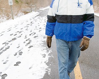 TAKING A WALK: Dave DiRienzo, 55, of Beaver Township, walks along East Golf Drive at Mill Creek MetroPark. DiRienzo, a teacher in Poland, said he typically takes a 40- to 50- minute walk once or twice a week through an area park, although he admits to going out "a lot more during the summer months."