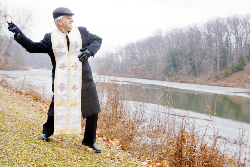 Father Daniel Rohan, of St. Marks Orthodox Church in Liberty, throws a wooden cross into Lake Glacier at Mill Creek Metro Park during The Great Blessing of Water ceremony held Tuesday afternoon.