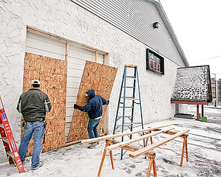 CLOSING A BAR: The Cell, a bar at 221 Belmonst Ave., is boarded up after Judge John M. Durkin of Mahoning County Common Pleas Court issued a temporary restraining order that declared it a public nuisance. Telly Dutton, left, and David Gordon, of National Fire Repair in Youngstown, apply the plywood.