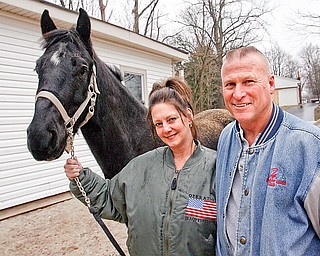 Peggy and John Geiss pose with Jet, her quarter horse. John Geiss, an Air Force Reserve master sergeant with the 910th Airlift Wing's Security Forces Squadron at the Youngstown Air Reserve Station in Vienna, gave his wife the horse to keep her company while she was holding down the home front during his six-month deployment to Iraq. He returned home last weekend.