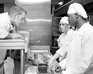 Chef Matthew Putzier overlooks the work of students Abbey Zarnick (17) of Greenford and Maurice Wallace (17) of Austintown have done for the practice cooking for MCCTC's new Oak Wood Restaurant in Canfield.