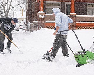 Chris Inskeep (18) of Hubbard and Ryan Foltz (25) of Hubbard shovel and plow Inskeep's grandmother's driveway in Youngstown, Saturday January 10, 2009