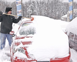 Sales and Leasing Professional Dennis Sima scrapes snow off of a Red Chevy Cobalt at Greenwood Chevrolet, Saturday January 10, 2009