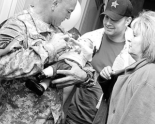 Staff Sgt. Rudy Santibanez Sr of Toledo holds his new granddaughter Aliviah (1 mth) as he stands next to his son Rudy Jr. and Rudy Sr's wife Joyce. Rudy Sr. just returned home from his 3rd tour in Iraq