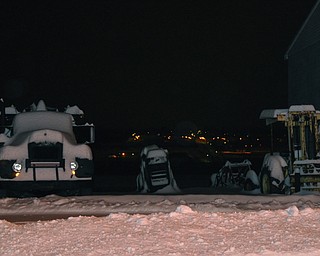 Trucks and other construction equipment at a Lowellville Road facility are almost hidden under inches of snow.