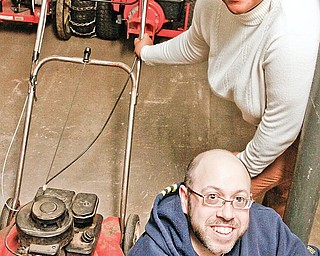 Weed & Seed Coordinator Terri Bryant (top) and Ricky George amongst donated lawnmowers for the Weed & Seed program