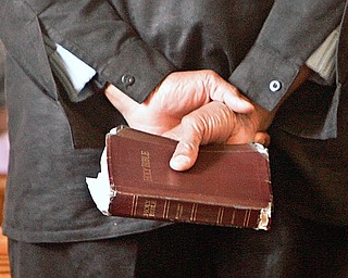 One of the members with a bible in his hand during opening prayers at Holy Trinity Missionary Baptist Church