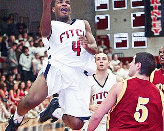 William Mahone of Fitch drives to the hoop past Donald D'Alesio of Mooney during Tuesday action at Fitch.