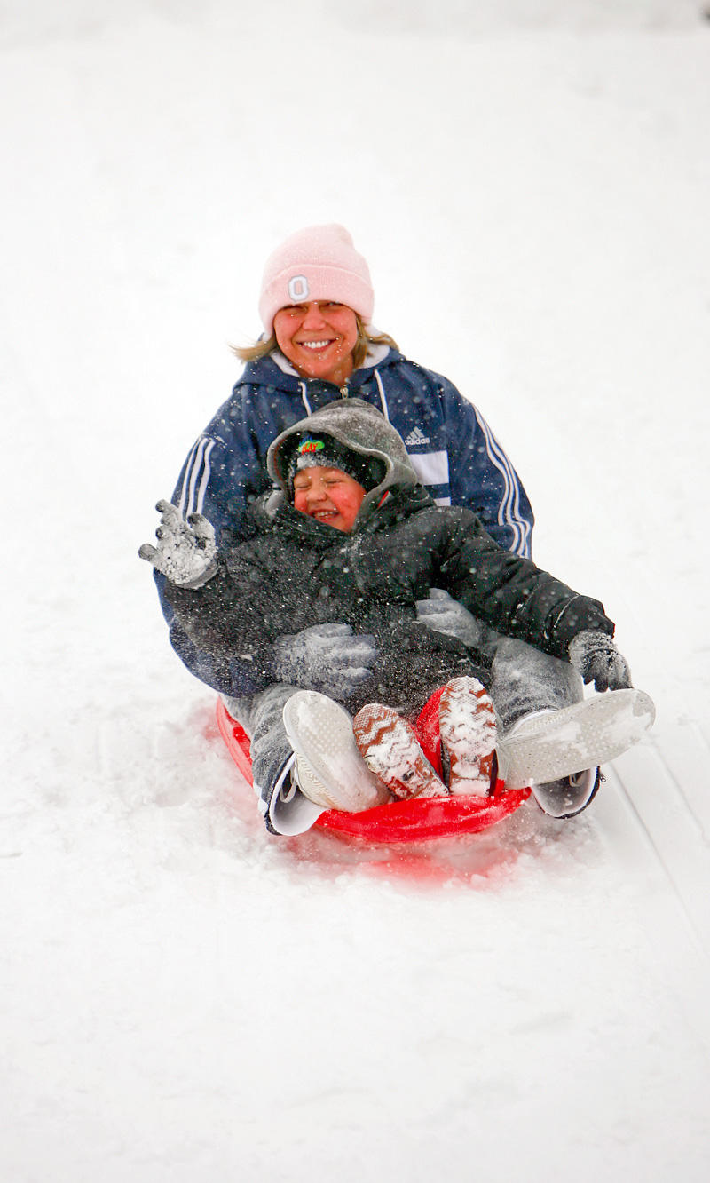Hayden, 3 1/2, and mom, Amanda Taylor of Hubbard, didn't let a little snow and cold stop their fun as they played on the hills in Wick Recreation area in Mill Creek Park