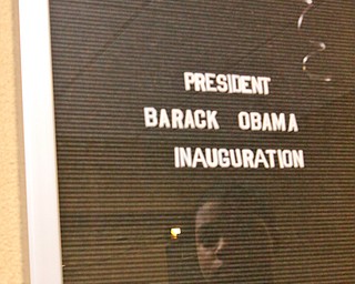 East High sophmore Hubert Hughley (15) is reflected through an announcement board at YSU Kilcawley Chestnut Room for Barack Obama's Inauguration, Tuesday January 20, 2009