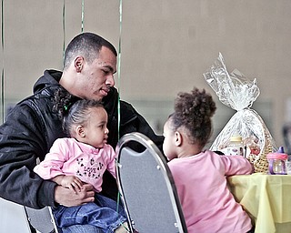 Sergio Rivera of Youngstown with his daughters London Rose (1) on his lap and Nevaeh (2) attend the 3rd annual City-Wide baby shower at McGuffey Center