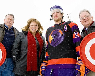 TAKING AIM: Hank Conrad, Poland Rotary president, left; Mary Ann Martinko, chairwoman of Poland Rotary's Chili Open Auction; Carl Nielsen, who plays defense for the Mahoning Valley Phantoms; and Larry Warren, Poland Rotary member, brave the cold while they gear up for Saturday's Chili Open, a "golf" tournament where participants try to hit hockey pucks into a goal manned by a Phantoms player.