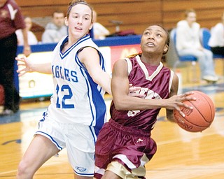 LEOPARDS ON THE LOOSE: Liberty's Vakeyla Merriweather (5) drives to the hoop past Hubbard's Cara Julian (12) during Wednesday's game at Hubbard High School. The Leopards downed the Eagles, 61-41.