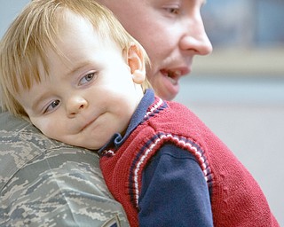 DAD'S BACK: Grayson Bonar, 1, of Vienna, rests on ther shouler of his father, Tech. Sgt. Jason Bonar. It's the first embrace between the two since Jason Bonar left for duty in Kirkuk, Iraq, more than six months ago. He returned home Thursday afternoon at Youngstown Air Reserve Station in Vienna with 12 other members of the 910th Security Forces Squadron.