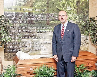Joseph Lane, president and chief operating officer of Lane Funeral Homes, stands with a green burial display that offers clients an explanation of a more natural and environmentally friendly form of burial. Green burial is defined as a body's returning to the earth naturally, without embalming fluid and with biodegradable materials.
