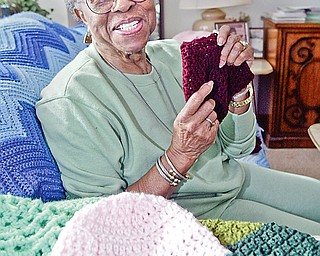 Lillie Smith of Youngstown with some of the crocheted hats she has made for chemo patients.