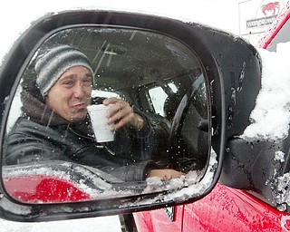 Snowplow driver Carl Dohar of Arrow Asphalt takes a break with a cup of coffee while plowing