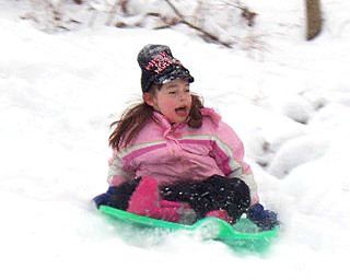 Katie, 6, takes a spin down the hill at Liberty Park.