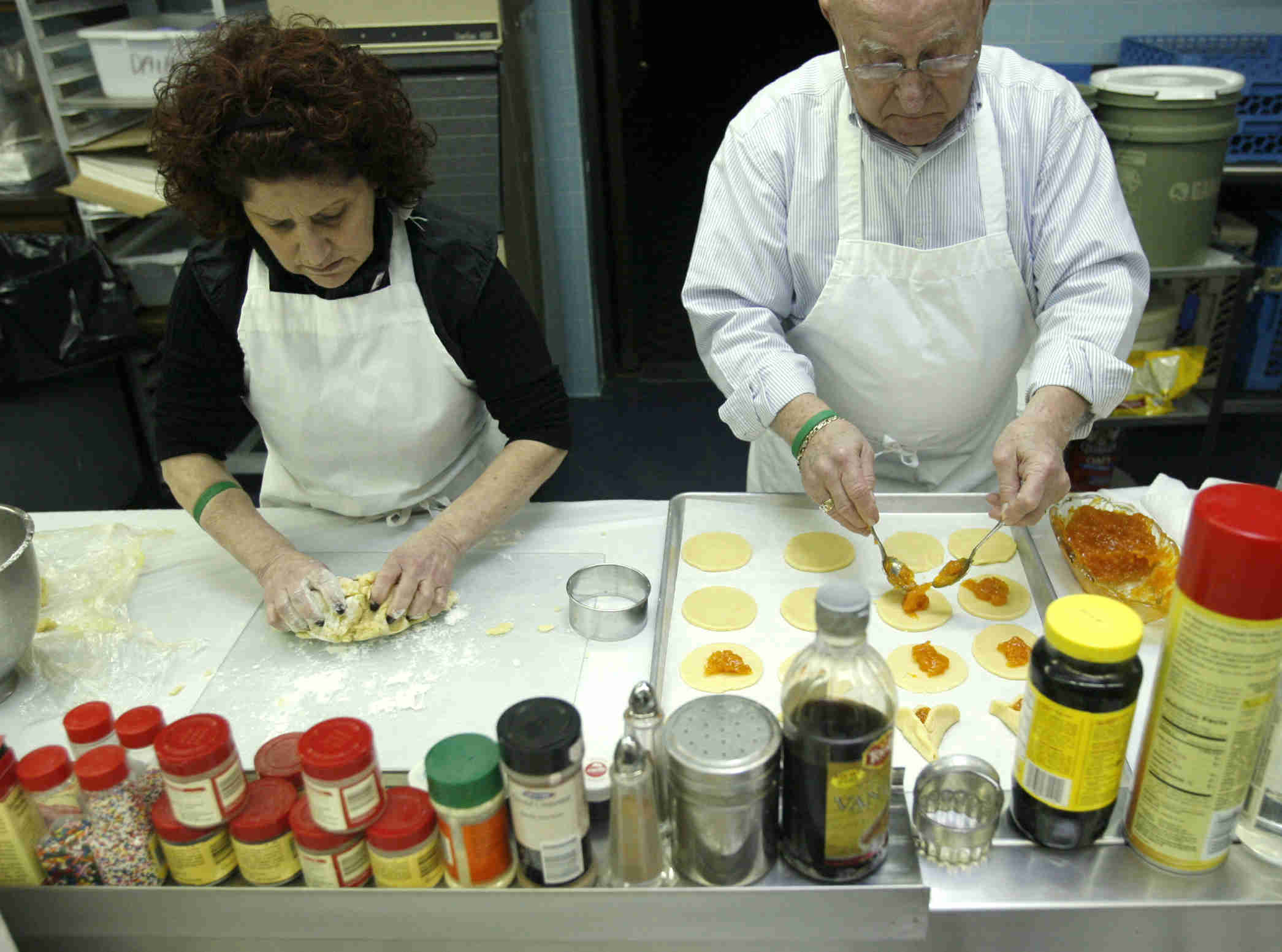 Sandy  and Sam Zians  roll dough and cut cookies and fill them  as the church makes Hamentaschen cookies for Purim- robertkyosay