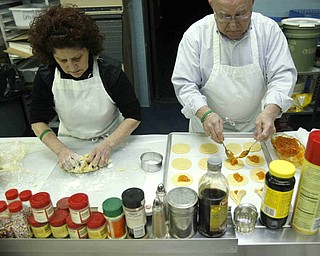 Sandy  and Sam Zians  roll dough and cut cookies and fill them  as the church makes Hamentaschen cookies for Purim- robertkyosay