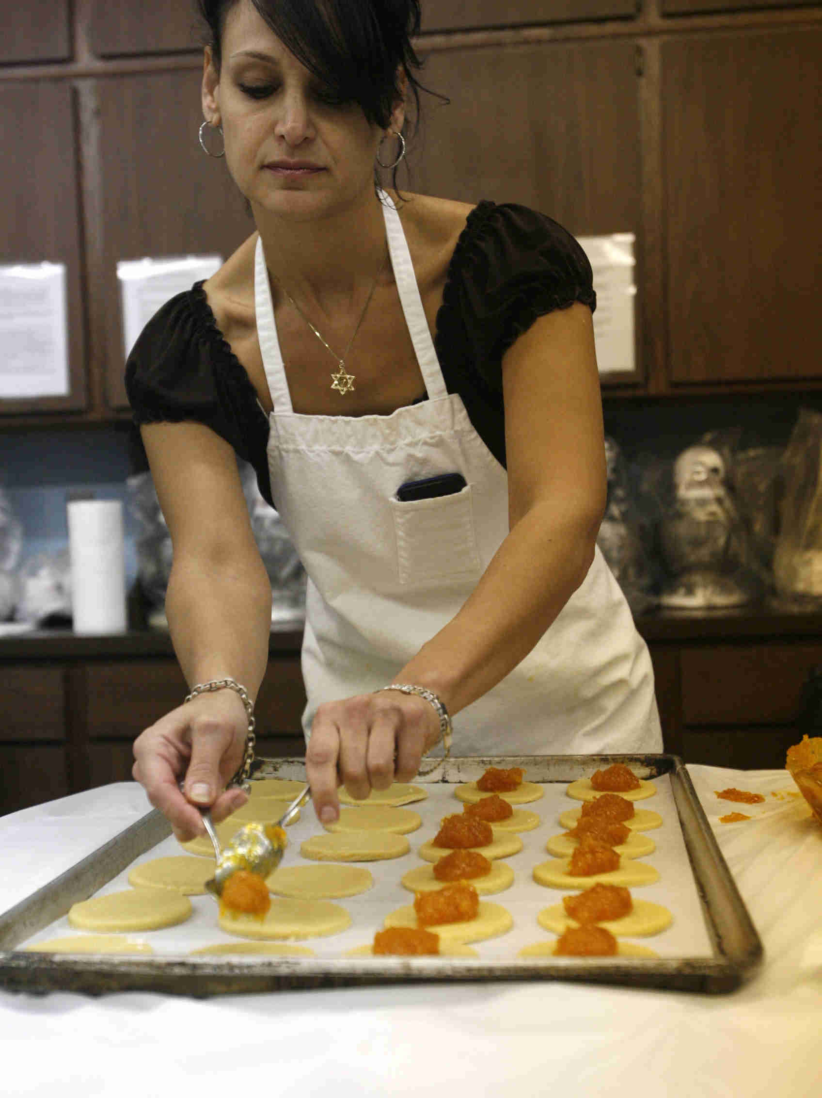 Stephanie Soloman a member of he Temple El Emeth Sisterhood places apricot fillin in the center o the cookie dough as the church makes Hamentaschen cookies for Purim- robertkyosay