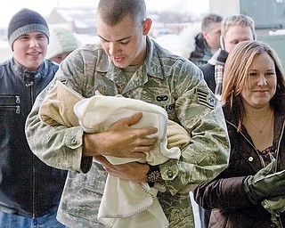 Staff Sgt. James Goodman, of Akron, carries his 3 week old daughter, Avery, flanked by his cousin, Sean Reese, of Dayton, and his wife, Amanda Goodman, after returning to the Youngstown Air Reserve Station in Vienna Ohio. Goodman is among 13 members of the 910 Airlift Wing's Security Forces Squadron who have been deployed at Kirkuk Air Base in Iraq for the past 6 months and returned Wednesday evening.