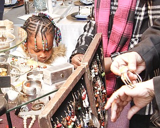 Janiyah Diggs (4) and her older sister Zariyah (12) of Warren inspects African cultural jewelry at YSU's African Marketplace for Black History Month in the Chestnut room at Kilcawley Center, Saturday February 7, 2009