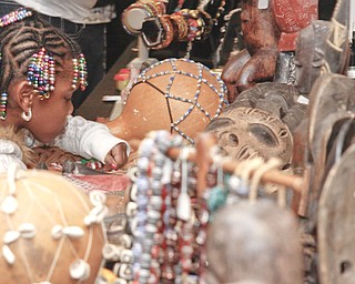 Janiyah Diggs (4) of Warren inspects African cultural artwork at Bette and Hardy Clifford's table for YSU's African Marketplace for Black History Month in the Chestnut room at Kilcawley Center, Saturday February 7, 2009