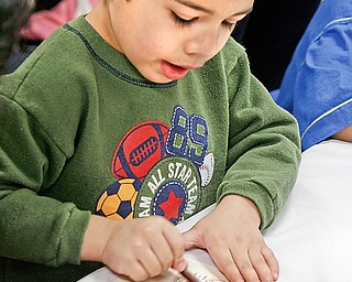The color of money is Jacob Wolf age 4 - colors the paper coins at the Librarys Smart Money program that was presented at Boardman Library by John Yingling