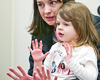 Tammie and Marissa 3, Conroy count the money on their hands as part of a game - at the Library's Smart Money program that was presented at Boardman Library by John Yingling
