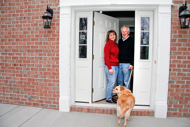 Dick and Sharon Wade with their dog R.T. on the front porch of their rebuilt home in Poland. The Wade's had a tree of their own that caused their home to be demolished.