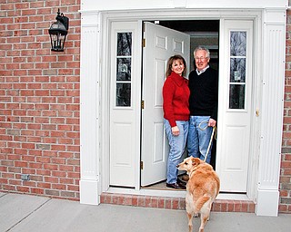 Dick and Sharon Wade with their dog R.T. on the front porch of their rebuilt home in Poland. The Wade's had a tree of their own that caused their home to be demolished.