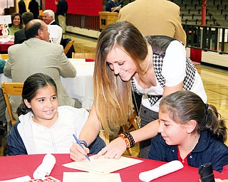 Kelsey Gurganus, middle, of YSU's womens basketball team gives her autograph to Marissa, left (8 1/2) and Gianna Lellio of Lowellville, right (10 1/2)