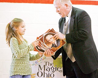 Jim Kleefeld gives photos of Ohios 8 presidents to Allison Cooper 4th grader as part of his THE MAGIC OF OHIO show to CH Campbell in Canfield.