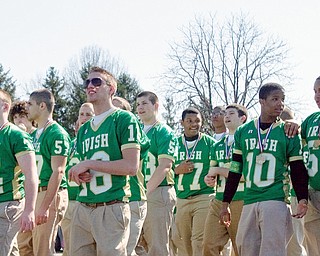Grand marshals and state championship winners, Ursuline's football team, walks along market street during the 31st annual Mahoning Valley St. Patrick's Day Parade.