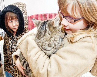 Jacquline Kish (7) holds her newly adopted cat, her sister Katherine (5) in back, at the Cat Ladies Society Rescue and Adoption, Thursday March 12, 2009