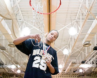 Isiaha Henderson (25) cuts off a piece of the net after Warren Harding defeated St. Ignatius 52-42 at Warrington Heights, Saturday afternoon.