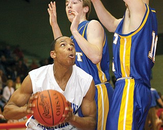 Youngstown Christian Olonzo Johnson (32) gets blocked from the hoop by East Canton Ryan Burfield (22) and JB DeRosa (10) at Struthers High School, Monday March 10, 2009