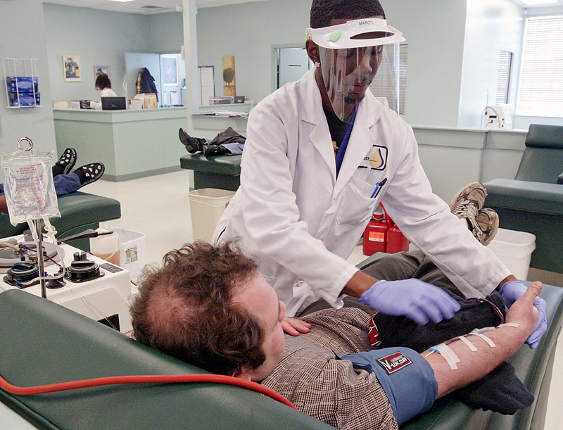 Marcel Lawrence, a phlebotomist at Bio Medics in Youngstown works with an unidentified plasma donor. 