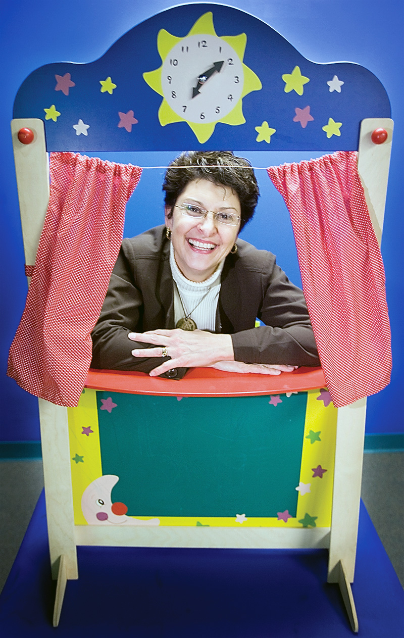 Executive Director, Suzanne Barbati, smiles through a puppet theatre at the Children's Center for Science and Technology on March 25, 2009. 
