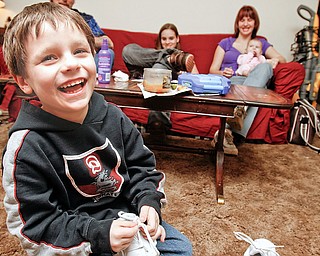 Mykle Datko (6) of Austintown laughs while untying his new shoes. Mykle is being sent to Disney World this weekend by Make A Wish Foundation, Wednesday March 25, 2009